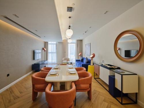 a room with a table and chairs and a mirror at The Muse in Doha