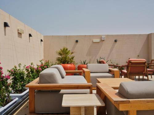 a patio with couches and tables and chairs at The Muse in Doha