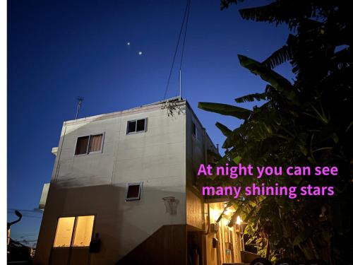 a building with a sign that says at night you can see many shining stars at お子様連れ&動物好き大歓迎！産みたての卵を収穫体験できる宿 in Nanjo