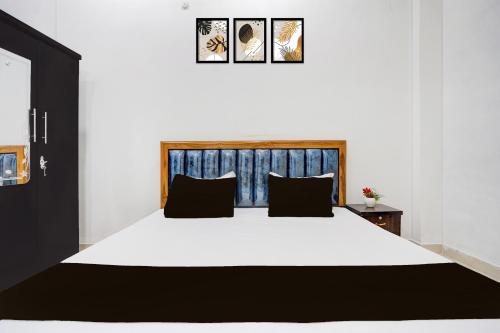 a bedroom with a large white bed with black pillows at Super Hotel O Prayagraj Sangam Railway Junction Formerly Veni Madhv Inn in Dārāganj