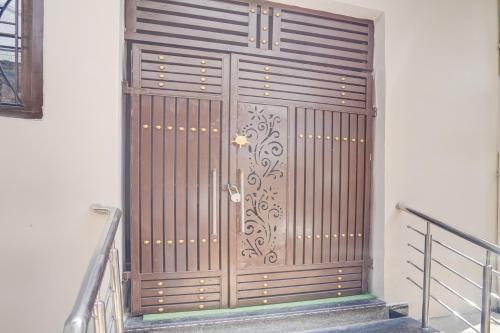 a large wooden door on the side of a building at Super Hotel O Prayagraj Sangam Railway Junction Formerly Veni Madhv Inn in Dārāganj