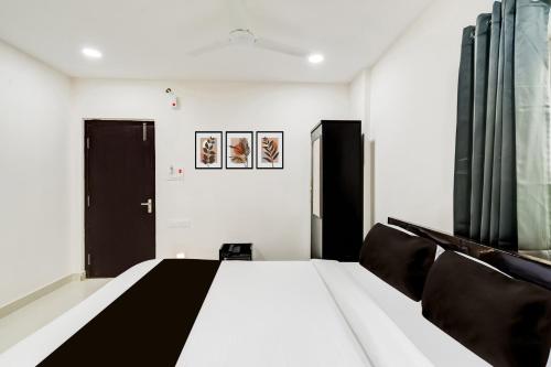 a bedroom with a bed with black and white sheets at Super Townhouse Golden Temple Manikonda in Gachibowli