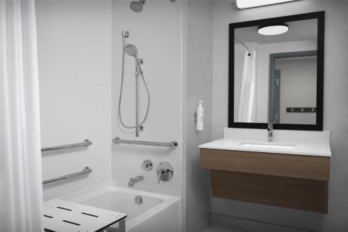 a bathroom with a tub and a sink and a mirror at Hampton Inn Indianapolis Downtown Across from Circle Centre in Indianapolis