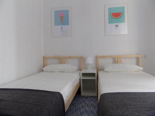 dos camas sentadas una al lado de la otra en una habitación en Apartament a la Placeta de Sant Joan 21, 3r, en Sant Feliu de Guíxols
