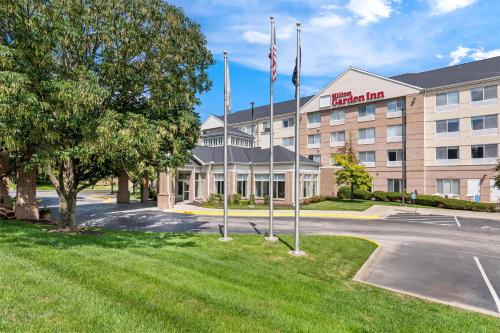 a hotel with flags in front of a building at Hilton Garden Inn Overland Park in Overland Park