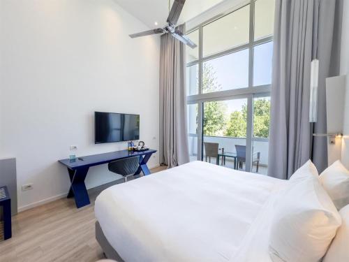 a hotel room with a bed and a desk and a window at Hilton Sorrento Palace in Sorrento