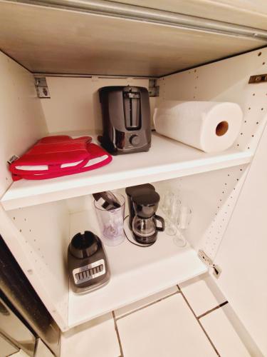 a kitchen shelf with a coffee maker and toilet paper at Nice 3BR Apt | 3 Beds |15 Min to NYC/Manhattan! in North Bergen