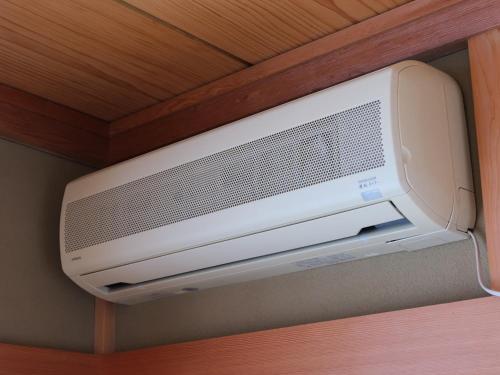 a television hanging from a ceiling in a room at Misaki Guesthouse in Kofu