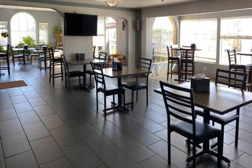 a dining room with tables and chairs and windows at Clarion Hotel By Humboldt Bay in Eureka