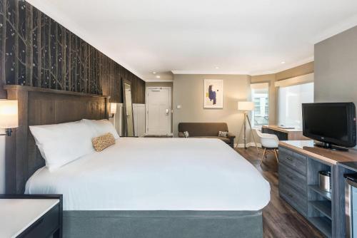 a bedroom with a large bed and a television at UpValley Inn & Hot Springs, an Ascend Collection Hotel in Calistoga