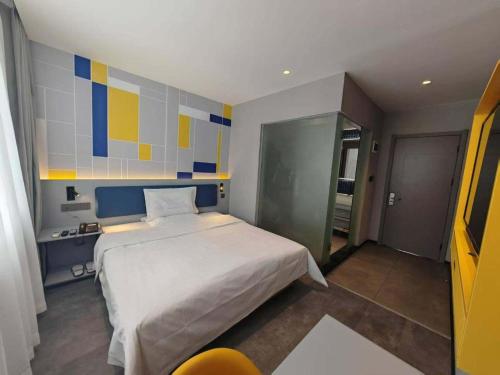 a bedroom with a white bed and a colorful wall at 7 Days Inn Hohhot Hailiang Xinhua Square Metro Station in Hohhot