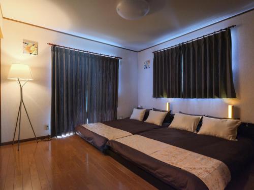a bedroom with a large bed and a large window at Misaki Guesthouse in Kofu