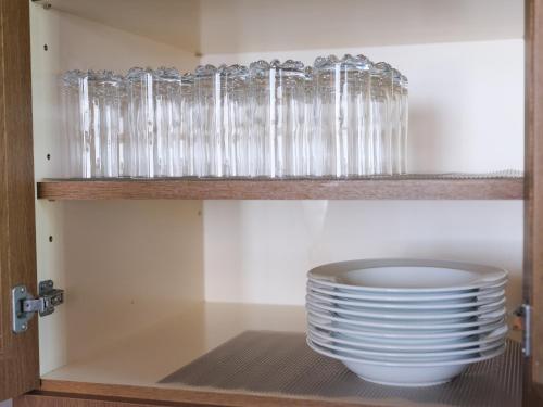 a cupboard filled with lots of glasses and plates at Misaki Guesthouse in Kofu