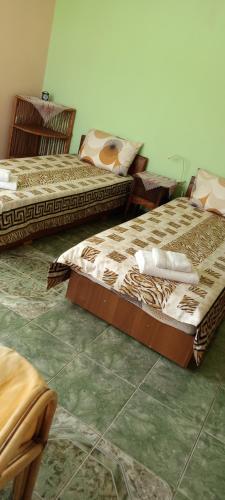 two beds are sitting in a room with at гостевой дом у Снежаны in Provadiya