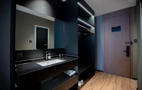 a bathroom with a sink and a large mirror at Xihe Langyue Hotel Beijing Changying Tianjie Branch in Beijing