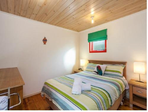 a bedroom with a bed and a wooden ceiling at Cora Lynn - Apartment 18 in Lorne