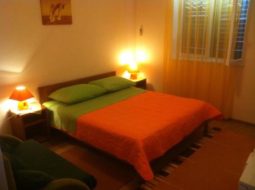 a bedroom with a bed and two lamps on tables at Rooms Ivica Vodice in Vodice
