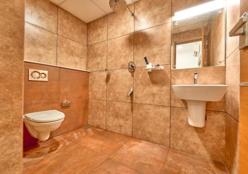 a bathroom with a toilet and a sink at Ashtamudi Luxe Villa by VOYE HOMES in Kollam