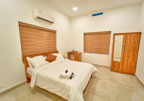 a bedroom with a bed with two pairs of shoes on it at Ashtamudi Luxe Villa by VOYE HOMES in Kollam