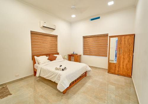 a bedroom with a large bed and a window at Ashtamudi Luxe Villa by VOYE HOMES in Kollam