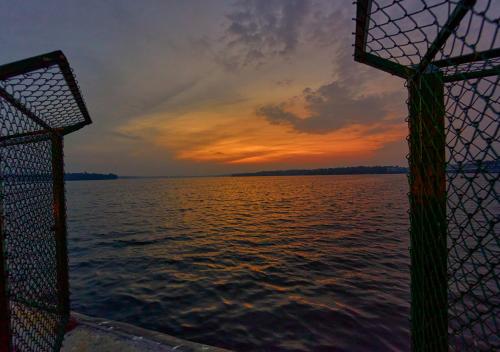 a view of the ocean from a boat at sunset at Ashtamudi Luxe Villa by VOYE HOMES in Kollam