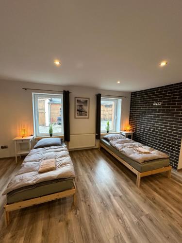 two beds in a room with two windows at Landhof Schadehorn "Hofblick" in Bad Oldesloe