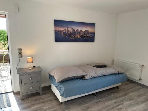 a bedroom with a bed with a picture on the wall at Landhof Schadehorn "Hofblick" in Bad Oldesloe