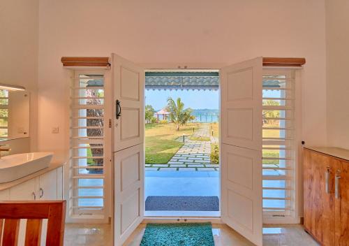 a kitchen with a door leading to a pool at Ashtamudi Luxe Villa by VOYE HOMES in Kollam