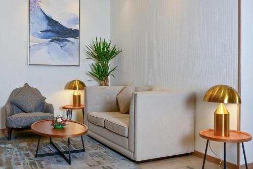 a living room with a couch and two tables at Comfort Hotel Jeddah King Road in Jeddah
