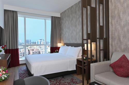 a hotel room with a bed and a chair at Comfort Hotel Jeddah King Road in Jeddah