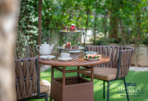 a table with a plate of food on it at Simantra Private Villas in Cha Am