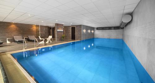 a large swimming pool in a hotel room at WestCord Fashion Hotel Amsterdam in Amsterdam