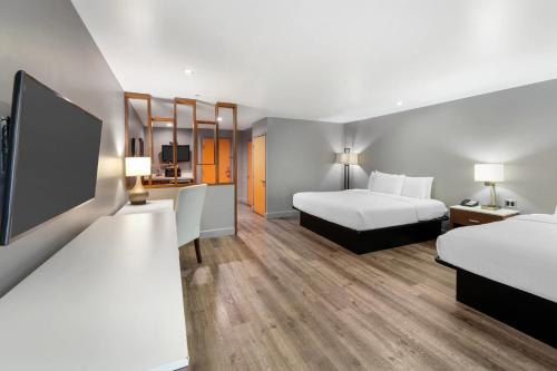 a hotel room with two beds and a flat screen tv at BLVD Hotel and Studios Universal-Hollywood, an Ascend Collection Hotel in Los Angeles