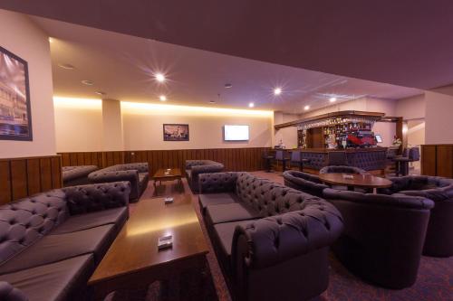 a waiting room with couches and tables and a bar at Hotel Transilvania in Alba Iulia