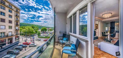 uma varanda com cadeiras azuis e vista para a cidade em BP Apartments Budapest em Budapeste