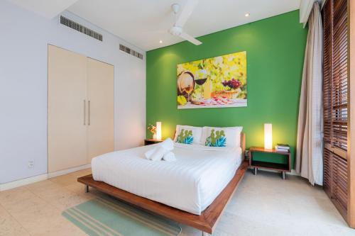 a bedroom with a white bed and a green wall at Park view Avalon Apartment District 1 HCM City in Ho Chi Minh City