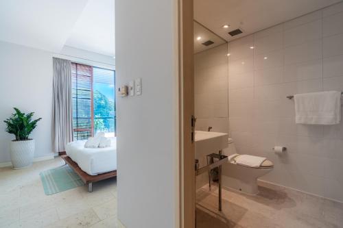 a bathroom with a bed and a sink and a toilet at Park view Avalon Apartment District 1 HCM City in Ho Chi Minh City