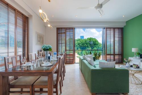 a dining room with a green couch and a table at Park view Avalon Apartment District 1 HCM City in Ho Chi Minh City