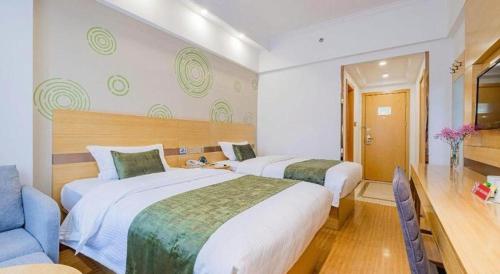 a hotel room with two beds and a couch at GreenTree Inn Shanghai Jingan Railway Station Xinzha Road Business Hotel in Shanghai