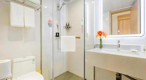 a bathroom with a toilet and a sink and a mirror at GreenTree Inn Shanghai Jingan Railway Station Xinzha Road Business Hotel in Shanghai