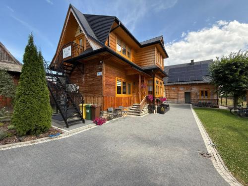 a large wooden house with a black roof at Apartamenty u Gąsiorów in Biały Dunajec