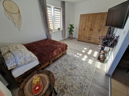 a bedroom with a bed and a table and a television at Bajkowe Studio Magdaleny 12 in Olsztyn