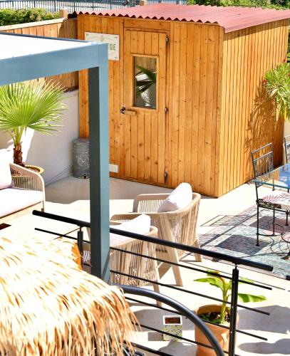 a patio with chairs and a wooden building at Lovely House in Besançon