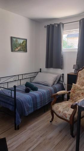 una camera da letto con un letto, una sedia e una finestra di Le petit havre a Igornay