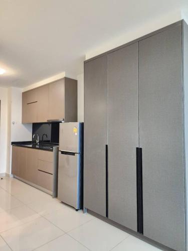 a kitchen with stainless steel cabinets and a refrigerator at The PeAk Residence, Multi-Apartment by Emma in Phnom Penh