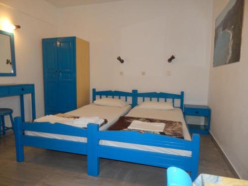 two beds in a room with blue cabinets at Dimitris studios in Kokkari