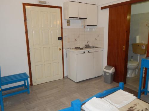 una pequeña cocina con fregadero y puerta blanca en Dimitris studios en Kokkari