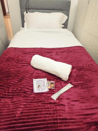 a bed with a towel and a book and a thermometer at Agile TRX Luxury Condo in Bukit Bintang in Kuala Lumpur