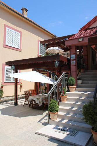 a patio with a table and an umbrella at Apartments Dragović Nikšić in Nikšić