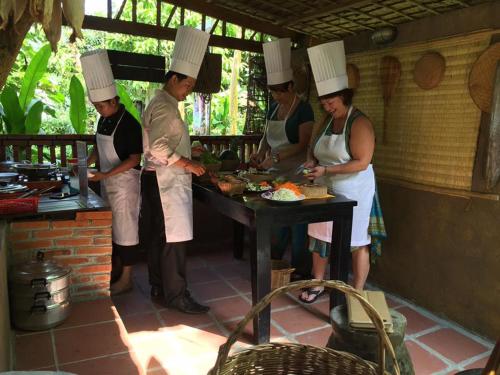 a group of people in chefs hats preparing food at The Sanctuary Villa Battambang in Battambang